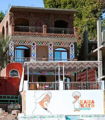 a building with a painting of a woman on a sign at Kana Kato in Aswan