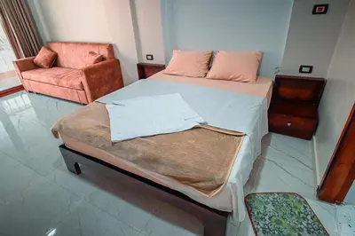 a bedroom with a large bed and a chair at Kana Kato in Aswan