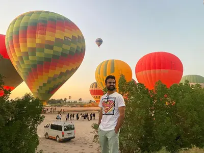 a man standing in front of a group of hot air balloons at Hadi Guest House in Luxor