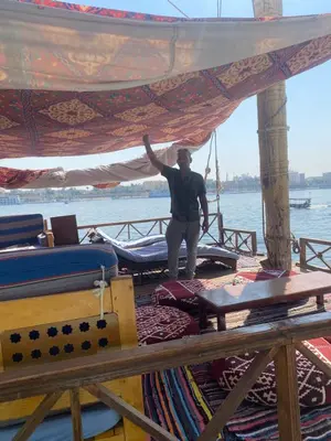 a man standing on the deck of a boat at Hadi Guest House in Luxor
