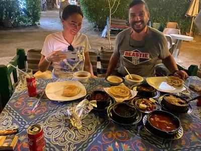 a man and a woman sitting at a table with food at Hadi Guest House in Luxor
