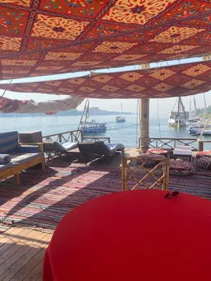 a deck with a view of the water with boats at Hadi Guest House in Luxor