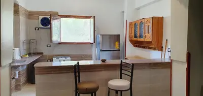a kitchen with a counter with two chairs and a counter top at Nile View Panoramique and Garden West bank in Luxor