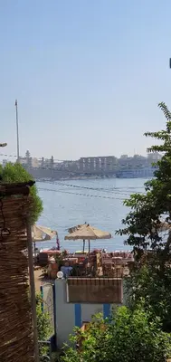 a view of a body of water with umbrellas at Nile View Panoramique and Garden West bank in Luxor