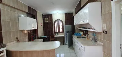 a kitchen with white cabinets and a sink at Nile View Panoramique and Garden West bank in Luxor