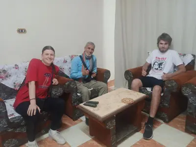 a group of three people sitting in a living room at Aswan City Center Guest House in Aswan