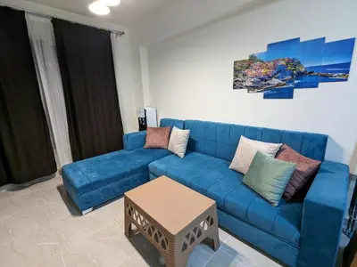a blue couch in a living room with a table at fully finished, very cozy and comfortable studio -Marina city Residence in Port Ghalib