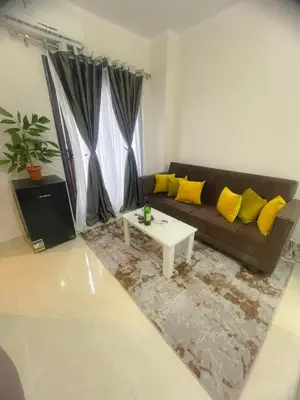 a living room with a brown couch and yellow pillows at Tropical 1 bed apartment in Hurghada
