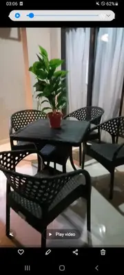 a table and chairs with a potted plant on it at Tropical 1 bed apartment in Hurghada