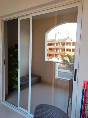 a sliding glass door with a view of a balcony at Florenza khamsin aprt F7 in Hurghada