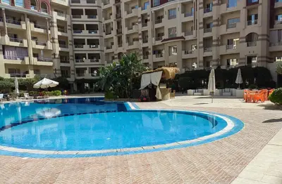 a large blue swimming pool in front of a building at Florenza khamsin aprt F7 in Hurghada