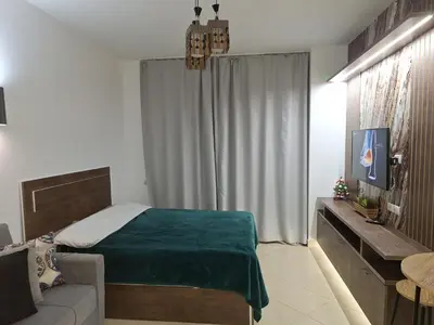 a bedroom with a bed and a tv and a couch at Florenza khamsin aprt F7 in Hurghada