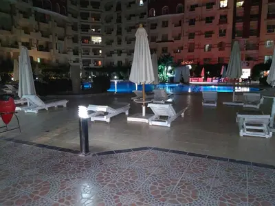 a courtyard with chairs and umbrellas in a building at Florenza khamsin aprt F7 in Hurghada