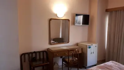 a bathroom with a sink and a mirror and a refrigerator at New Pola Hotel in Luxor
