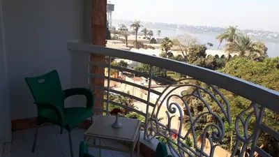 a room with a balcony with a view of the ocean at New Pola Hotel in Luxor