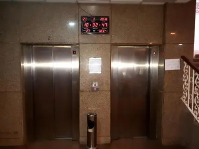 two elevators in a building with a clock on the wall at New Pola Hotel in Luxor