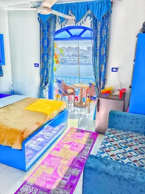 a bedroom with two beds and a table and chairs at Airkela Nuba Dool 2 in Aswan