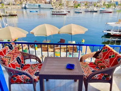 a table and chairs on a balcony overlooking a marina at Airkela Nuba Dool 2 in Aswan