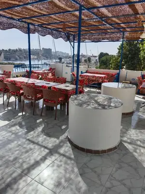 a group of tables and chairs under a roof at Airkela Nuba Dool 2 in Aswan