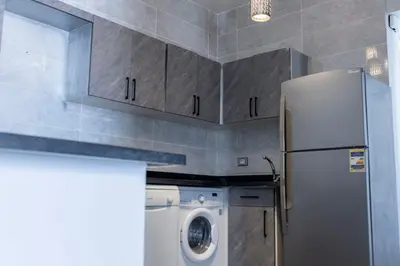 a kitchen with a refrigerator and a washing machine at El Gouna Elite Worldwide Sea & Garden Residences - Hurghada, Egypt in Hurghada