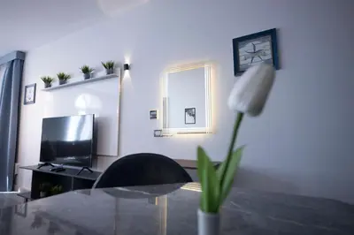 a living room with a tv and a table with a flower at El Gouna Elite Worldwide Sea & Garden Residences - Hurghada, Egypt in Hurghada