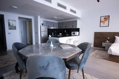 a dining room with a table and chairs and a bed at El Gouna Elite Worldwide Sea & Garden Residences - Hurghada, Egypt in Hurghada