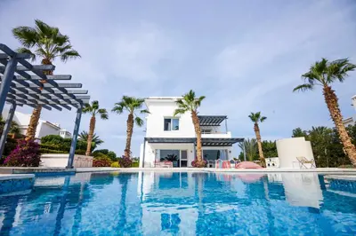 a swimming pool in front of a house with palm trees at El Gouna Elite Worldwide Sea & Garden Residences - Hurghada, Egypt in Hurghada