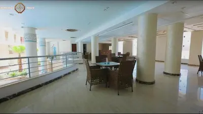 a room with chairs and a table on a balcony at Casablanca beach resort, first line, with private beach and swimming pools,hurghada in Hurghada
