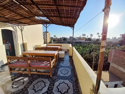 a patio with tables and chairs on a balcony at Lucky House in Luxor