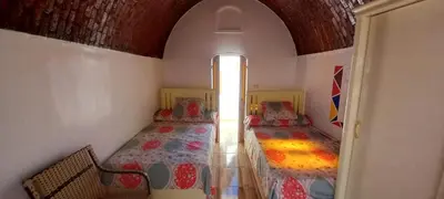 a bedroom with two beds in a room with a window at Casablanca Guest House in Aswan