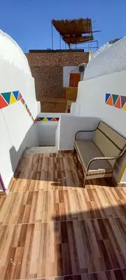 a room with a bench on a wooden floor at Casablanca Guest House in Aswan
