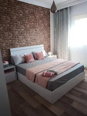 a bedroom with a large bed with a brick wall at Alena Lempachova in Hurghada