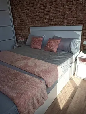 a bed with two pillows and a brick wall at Alena Lempachova in Hurghada