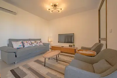 a living room with a couch and a tv at Modern 1-Bedroom Apartment in G-Cribs, El Gouna, pool access in Hurghada