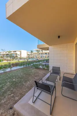 a group of chairs sitting on a patio at Modern 1-Bedroom Apartment in G-Cribs, El Gouna, pool access in Hurghada