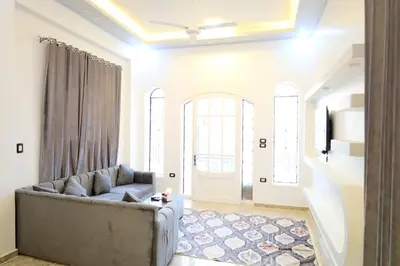 a living room with a couch and a door at Tomorrow Land villa in Luxor