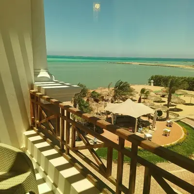 a balcony with a view of the beach and the ocean at Tony's Privy Beds by Red Sea in Hurghada