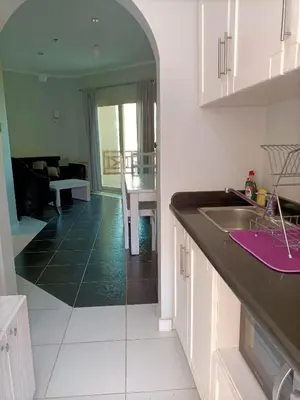 a kitchen with a sink and a living room at Tony's Privy Beds by Red Sea in Hurghada