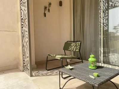 a chair and a table and a chair on a balcony at Mangroovy - 1BR Glamorous Gouna view condo in Hurghada