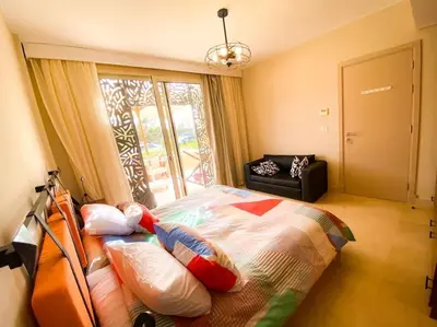 a bedroom with a bed with pillows and a window at Mangroovy - 1BR Glamorous Gouna view condo in Hurghada