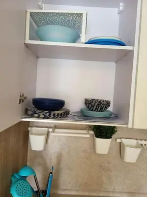 a shelf with bowls and other dishes on it at Mangroovy Ritzy, Cerulean appartement by the pool in Hurghada