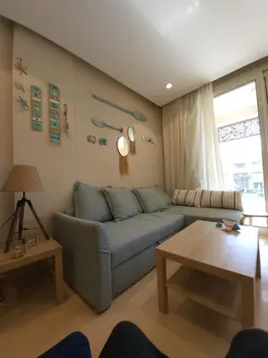 a living room with a blue couch and a table at Mangroovy Ritzy, Cerulean appartement by the pool in Hurghada