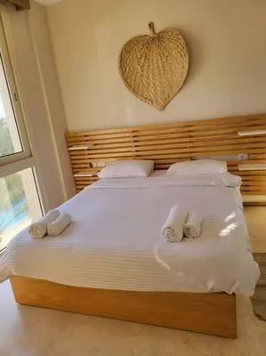 a bedroom with a large bed with towels on it at Mangroovy - 2BR Marvelous Pool View Apartment in Hurghada