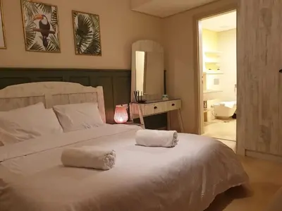 a bedroom with a white bed with two towels on it at Mangroovy - 1BR GF +2 wall beds Garden & Pool view in Hurghada