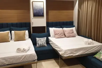 two beds sitting next to each other in a room at Mangroovy - 1BR GF +2 wall beds Garden & Pool view in Hurghada