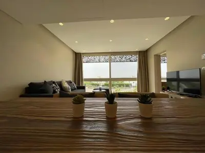 a living room with three potted plants on a table at Mangroovy - 1BR Ravishing Lake and Mountain View in Hurghada