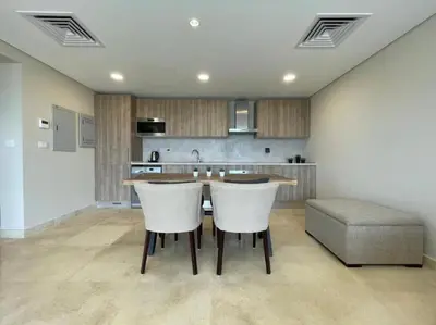 a kitchen with a table and chairs and a couch at Mangroovy - 1BR Ravishing Lake and Mountain View in Hurghada