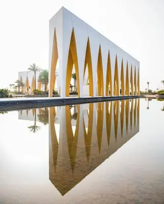 a building with its reflection in the water at Mangroovy - 1BR Ravishing Lake and Mountain View in Hurghada