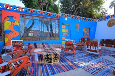a blue room with colorful chairs and a table at Nubian studio in Aswan