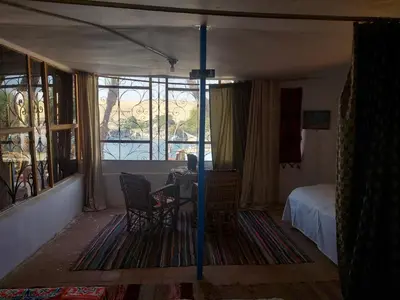 a bedroom with a bed and a table and chairs at Nubian studio in Aswan